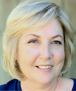 A woman with short blond hair smiles at the camera.